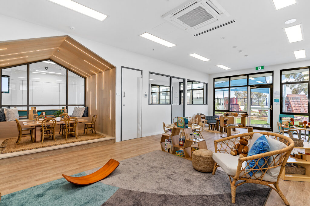 Nido Essendon Living room with small wooden table, chairs, baskets, pillows and windows