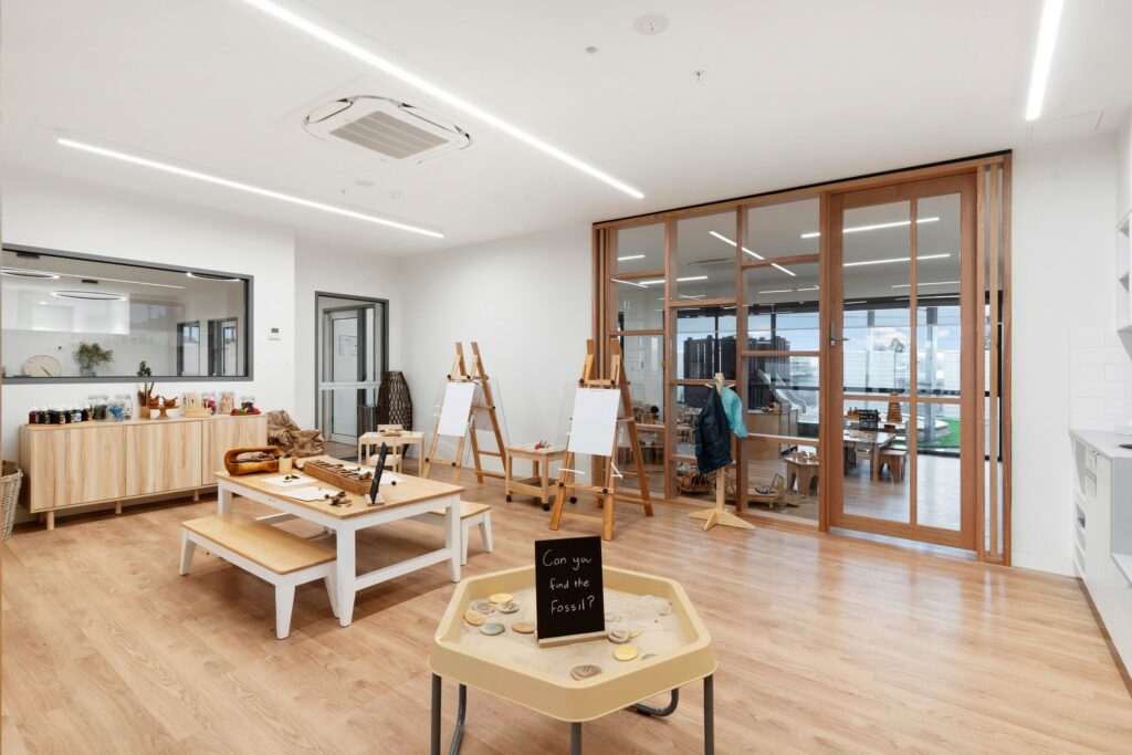 Nido Avondale Heights room with small wooden benches, cupboards, stand with white board, basket and transparent window