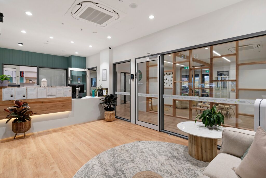 Nido Avondale Heights Room with wooden floor, glass door, small artificial plants, sofa chair and pillows