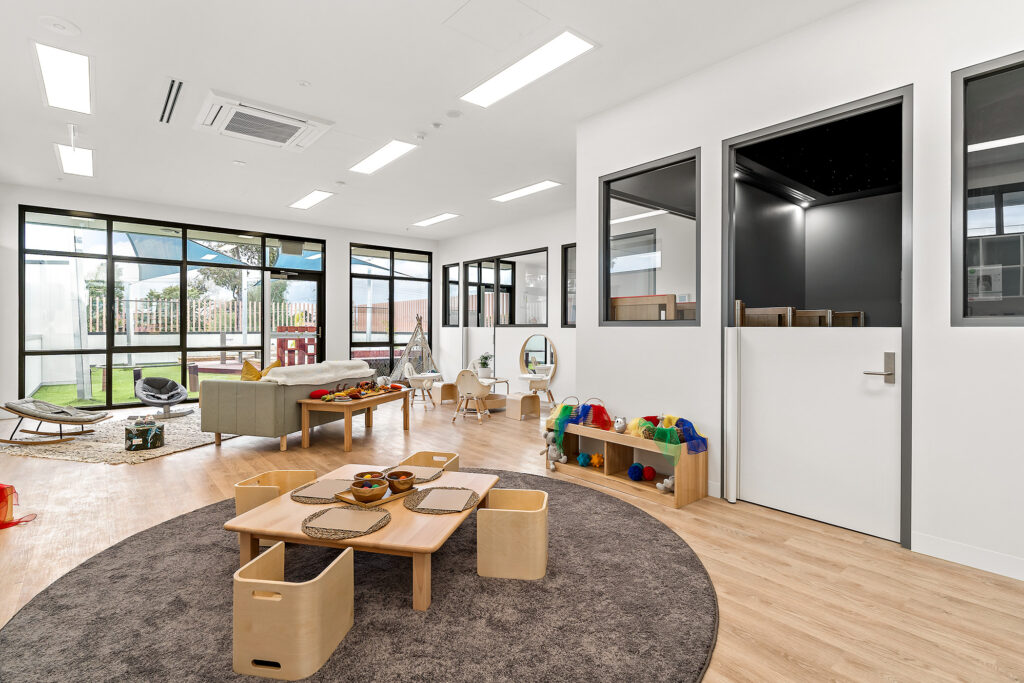 Nido Essendon Living room with small chairs, table, door, transparent windows and mirror