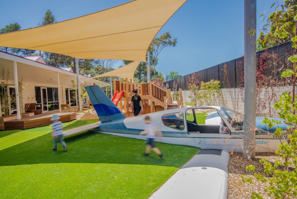 children playing with a toy aeroplane at nido child care centre at belair