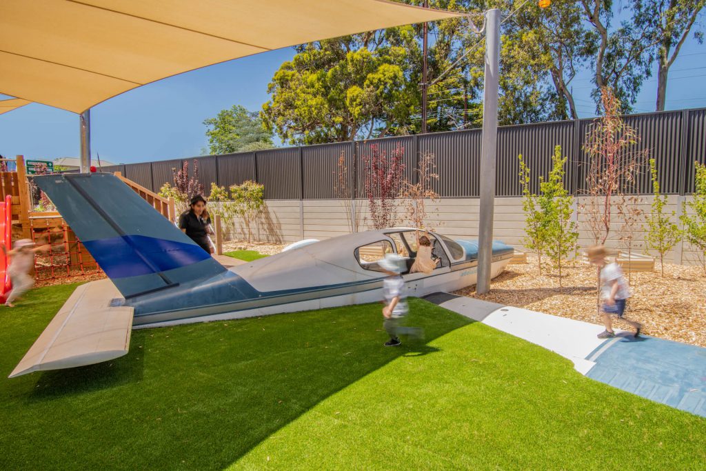 children playing with a toy aeroplane at nido child care centre at belair