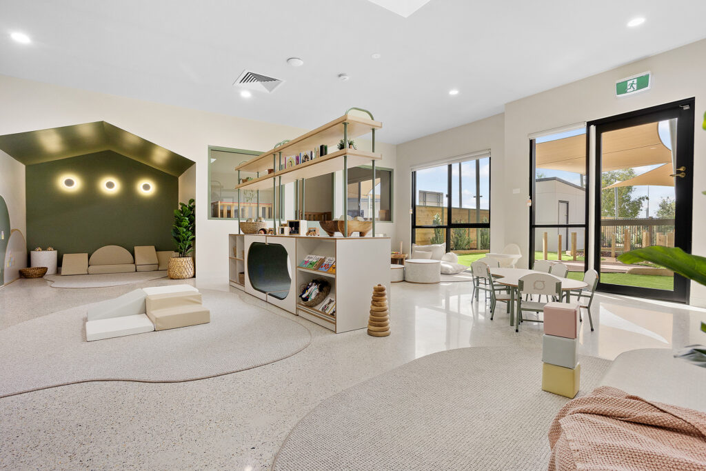 Playroom at Nido Butler Childcare Centre showcasing a green wall and white floor
