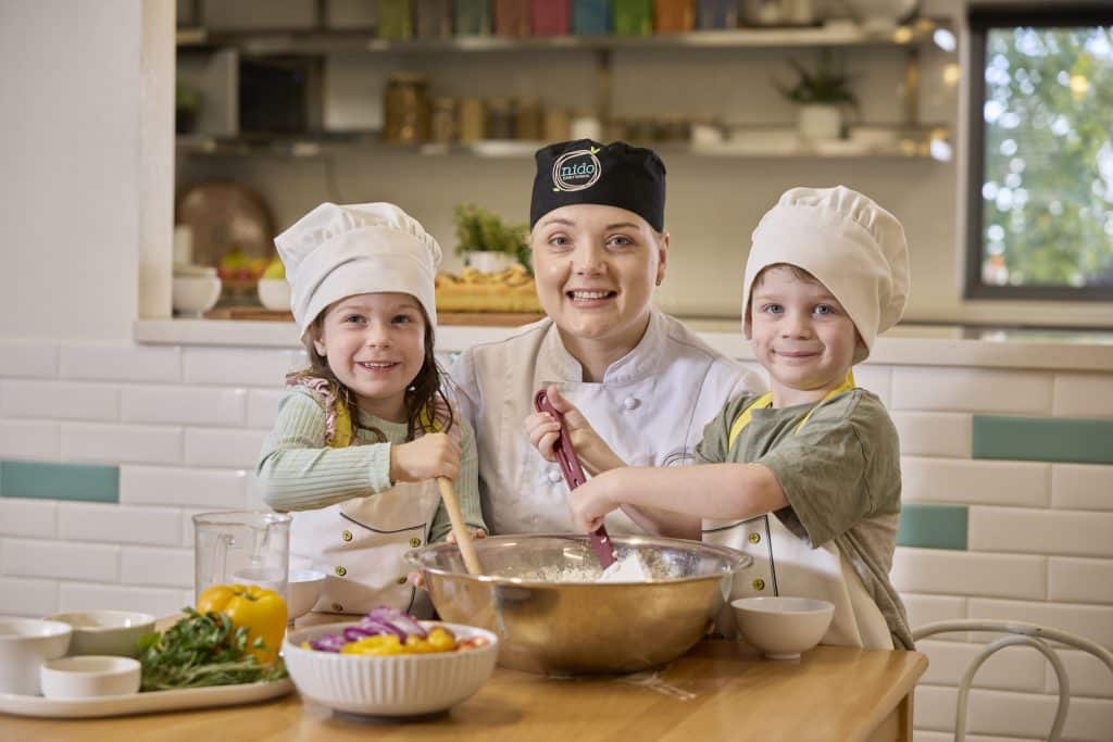 Children cooking with educator at Nido Belair child care