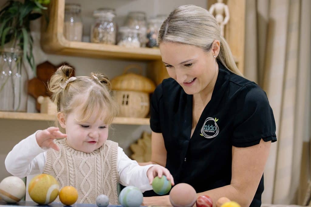 Nido Early School Educator and a child organising the solar system together